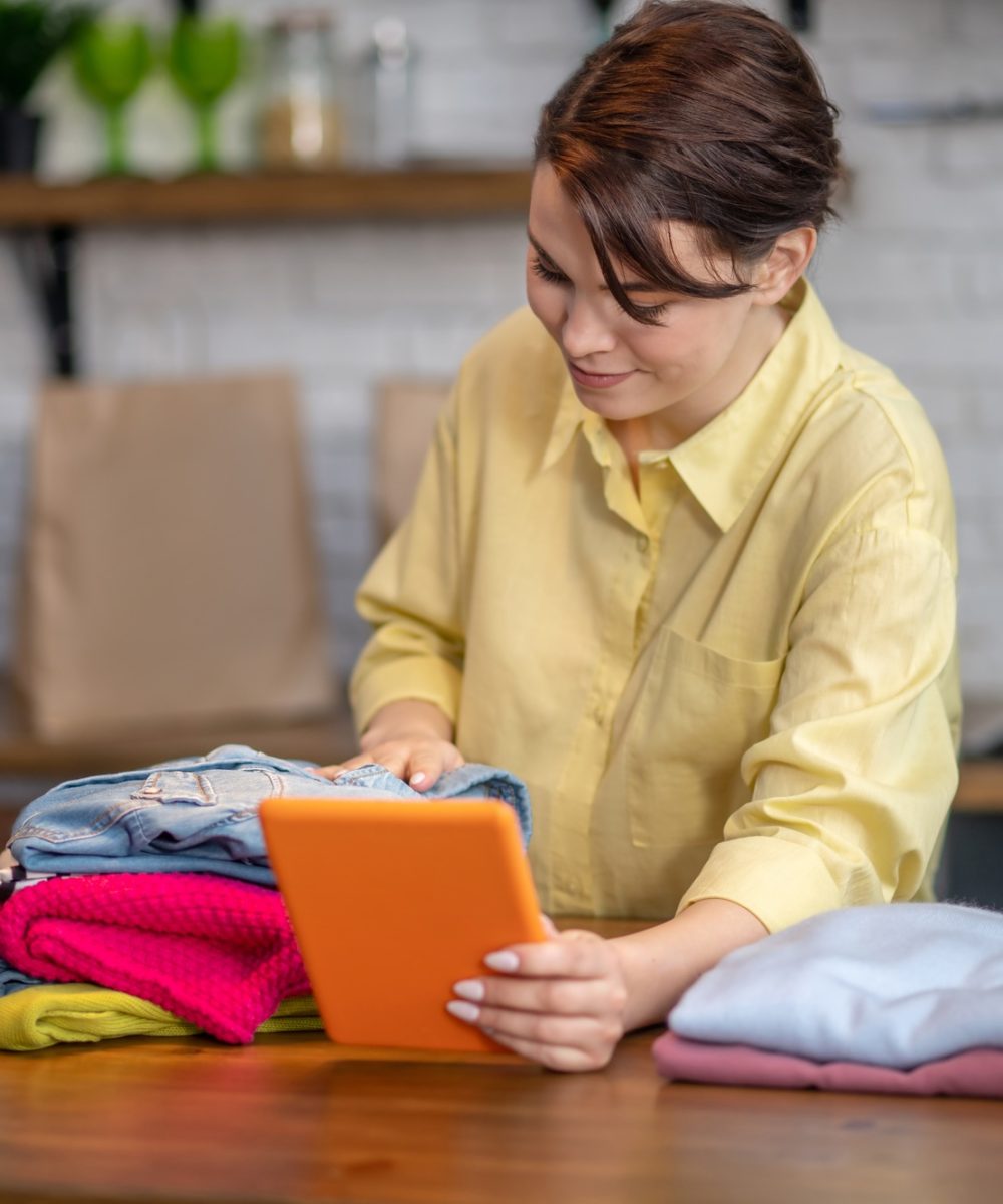 Woman taking photos of items of clothing